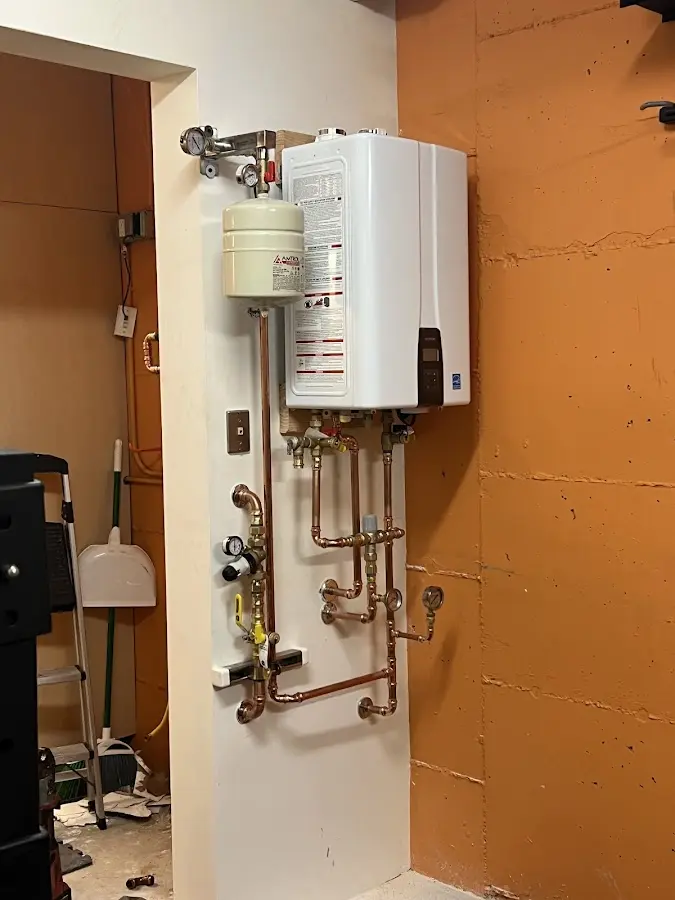 Plumbing technician inspecting water heater connections in Barstow